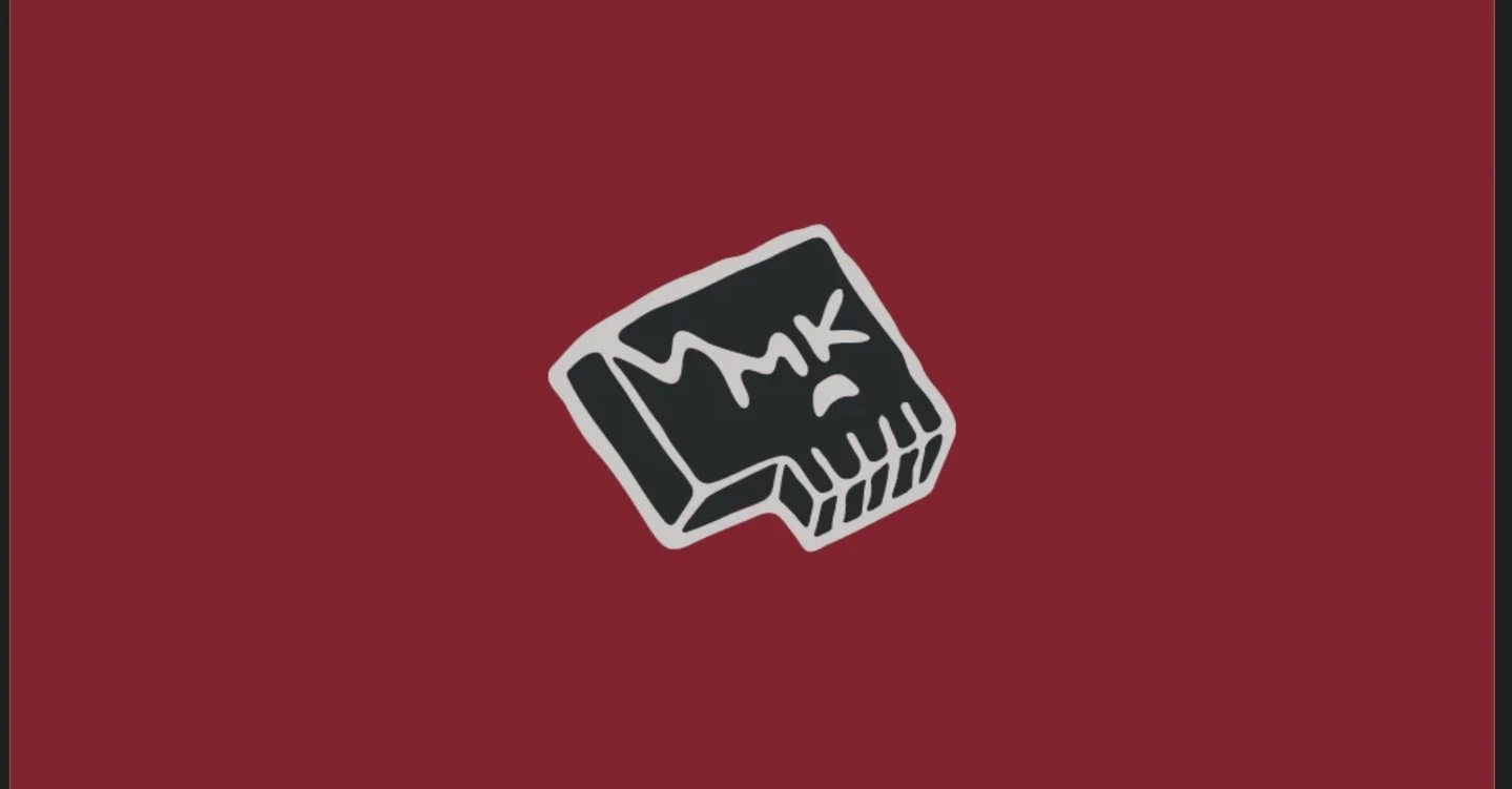 The hand-drawn MK monogram sticker on a crimson field.